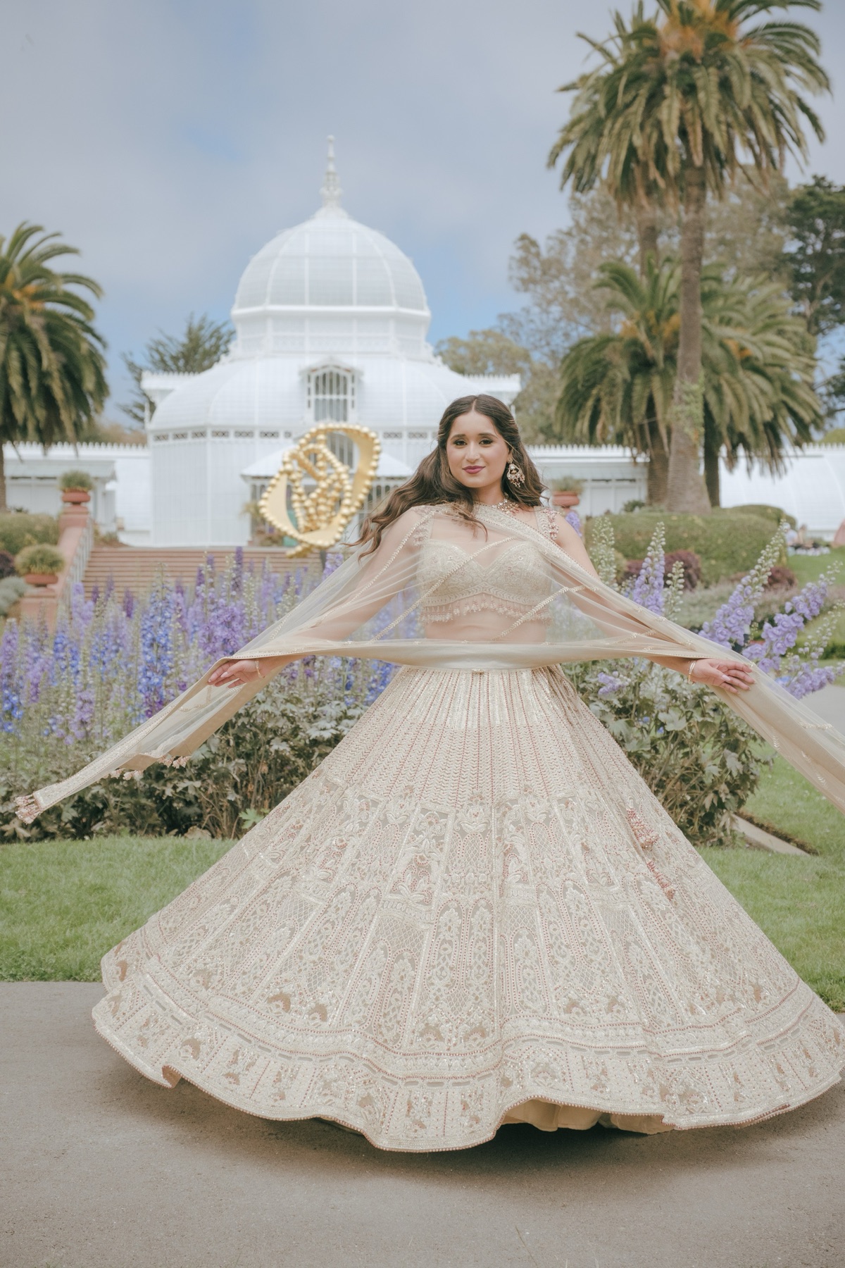 Indian bride twirling in a lehenga outside the Conservatory of Flowers, San Francisco wedding photography by Matt Dea